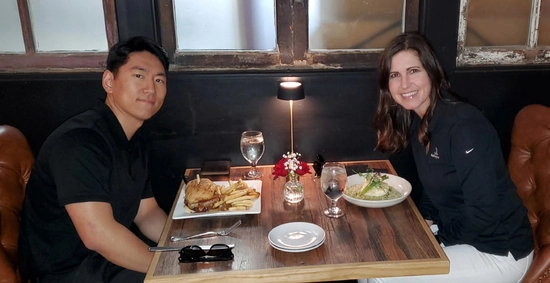 Vanessa Klemme VanDeWiele and Daewon Kim sit together at a table in a restaurant.