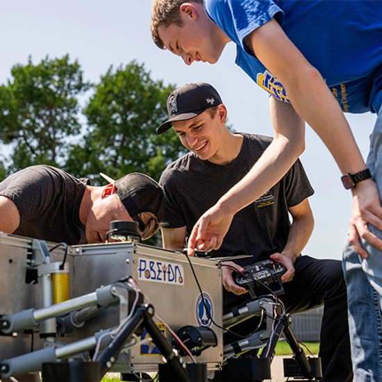 Male engineering students working on a robotic structure